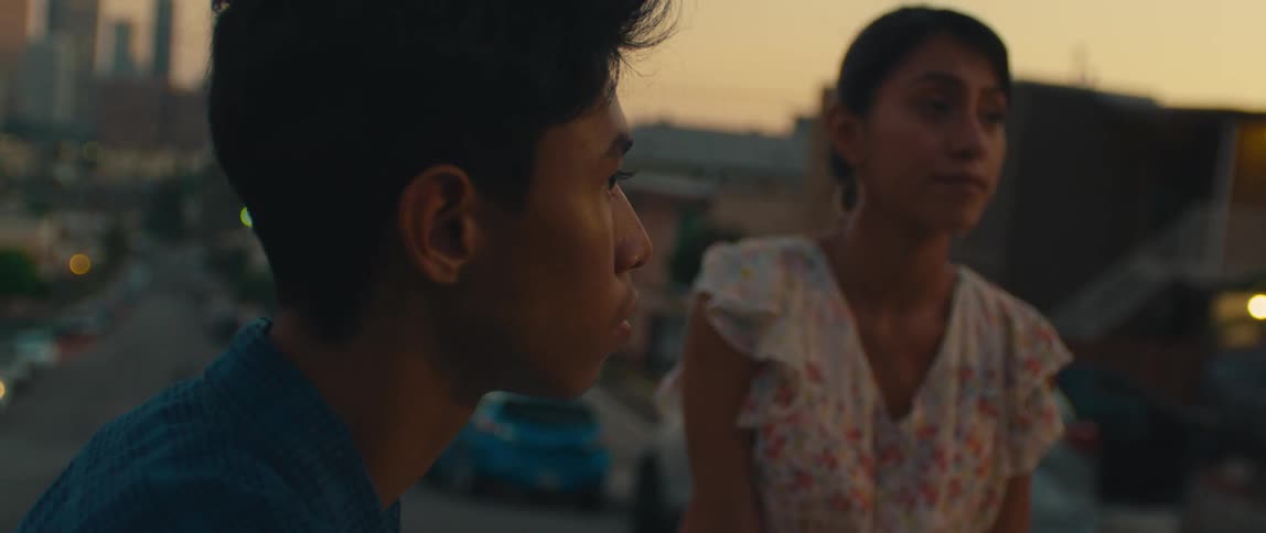 Young people watch the city at sunset from a neighborhood street