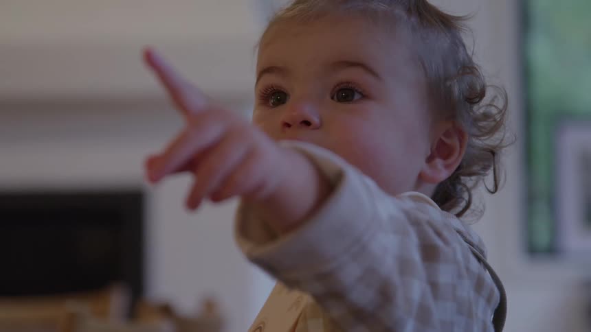 The face of a little girl with her finger in her mouth and then the tip pointing forward