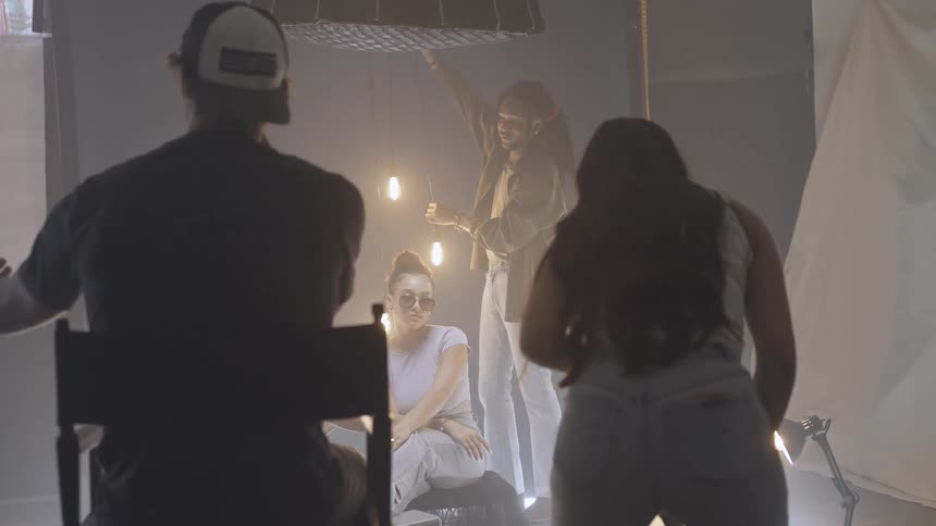 Crew sets up lighting in a studio during scene preparation