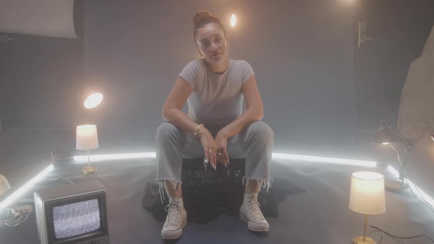 The model is smiling and dancing as she sits