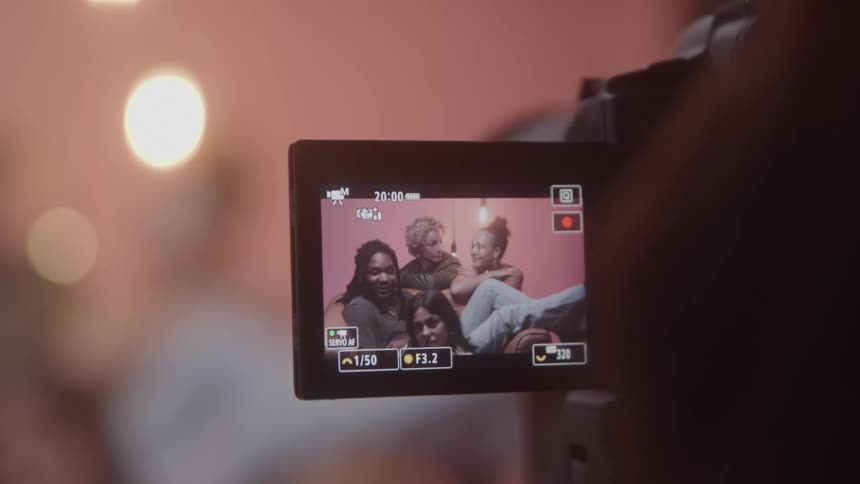 Group of friends smiling appears on a camcorder screen