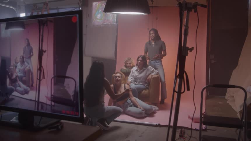 Woman talking to another group of women in a studio with a recording screen in the foreground
