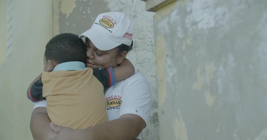 A woman holds and hugs a young boy
