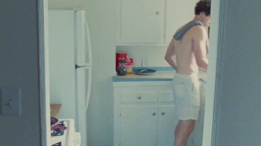 Teenager in his boxers walking into kicthen grabbing a glass of orange juice