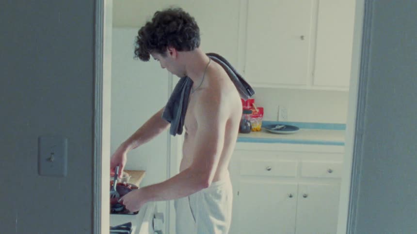 A man cooks food in a small kitchen
