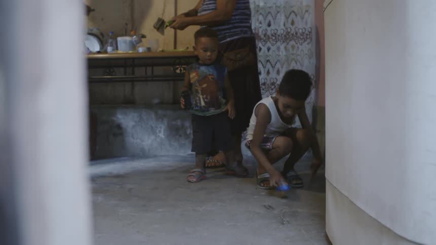 Two children playing with toy cars on floor in home