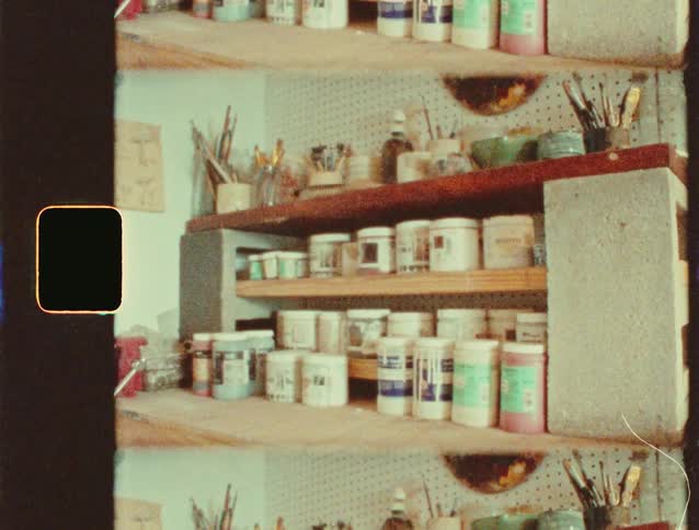 Studio shelves organize paint jars and brushes