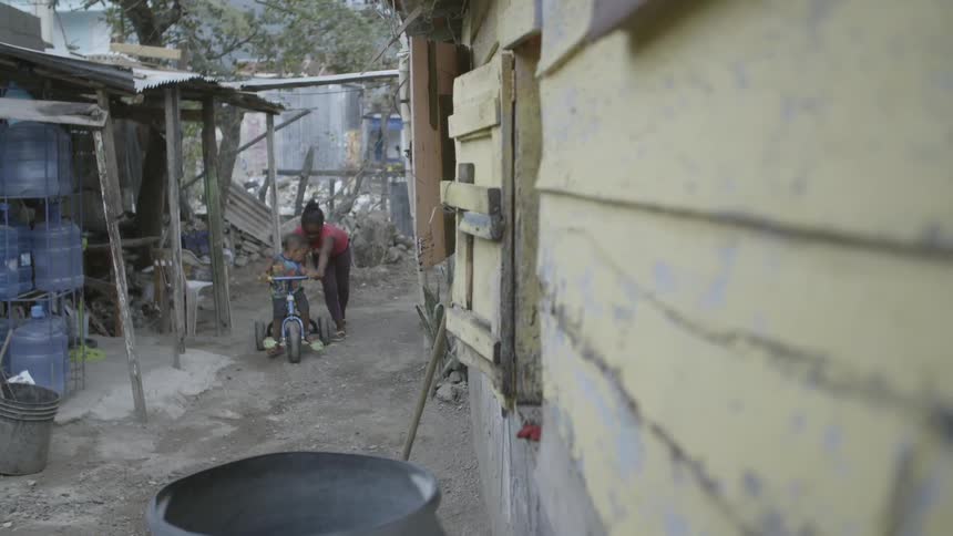 Girl pushing little boy on bicycle