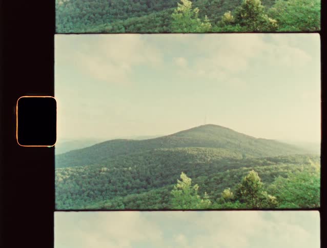 A scenic view of green mountains under a bright sky