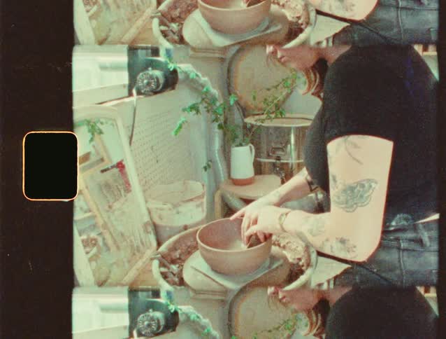 A woman shapes a pot in a workshop