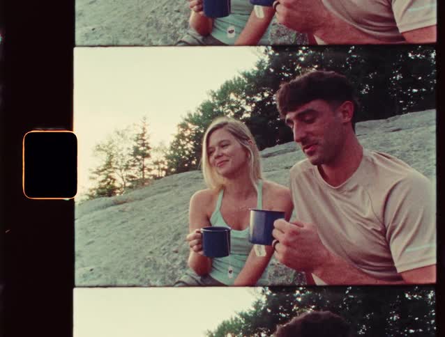 A man and woman are drinking tea and talking on the hill