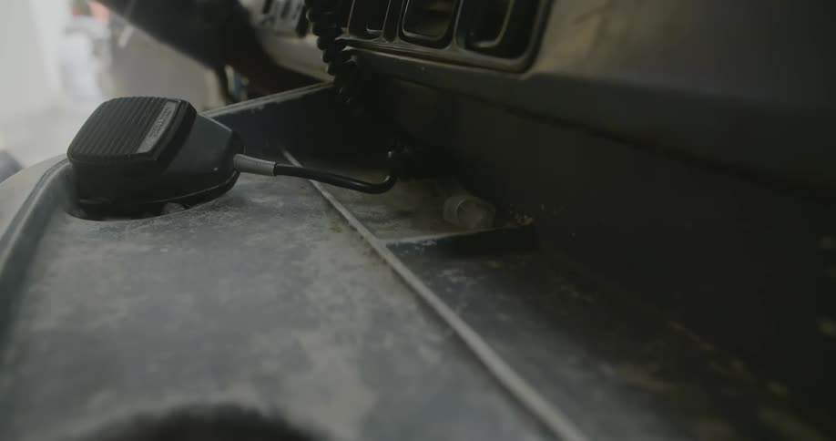 A cb radio mic on a dusty dashboard