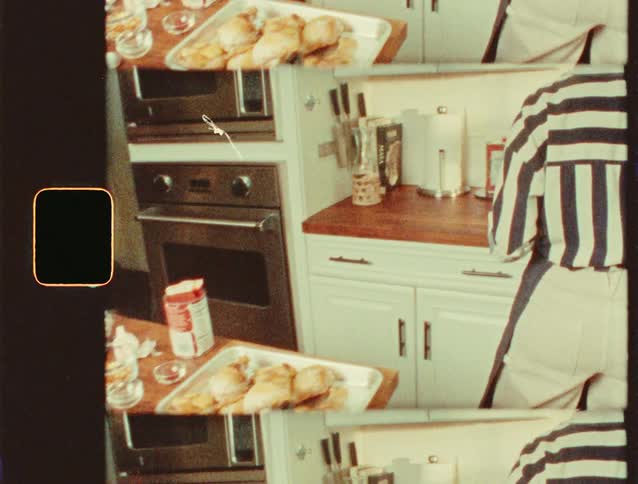 The woman is cooking chicken in the kitchen