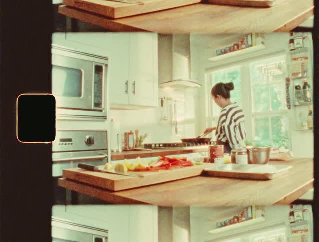 A woman prepares food in a bright kitchen