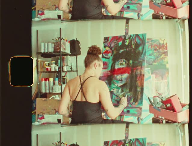 A woman paints an abstract portrait in her studio