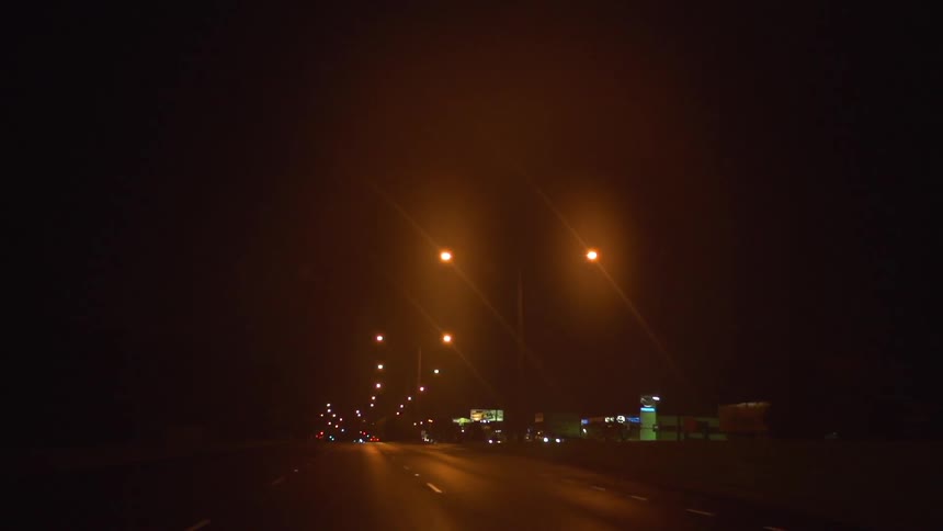 A road at night time with lamp posts above