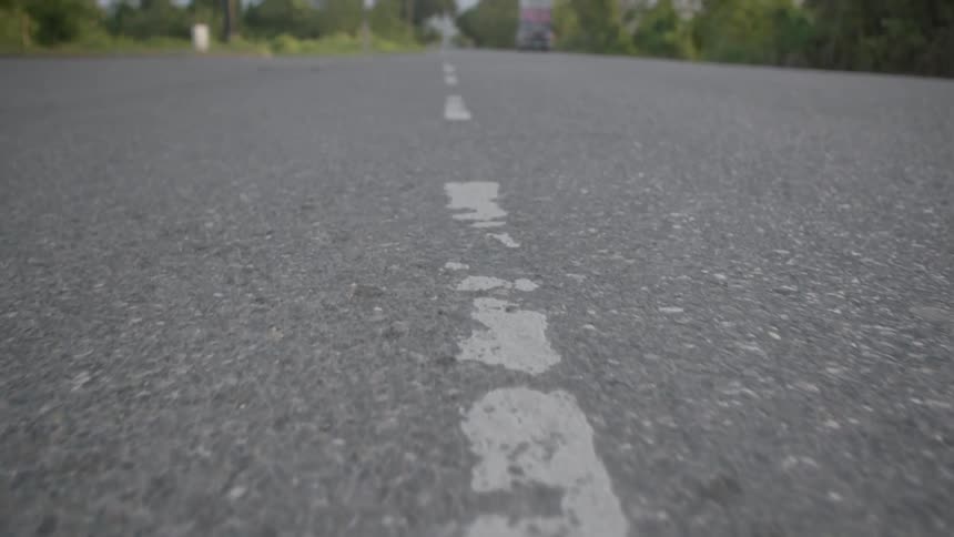 An old worn out street line is shown running down the middle of a street