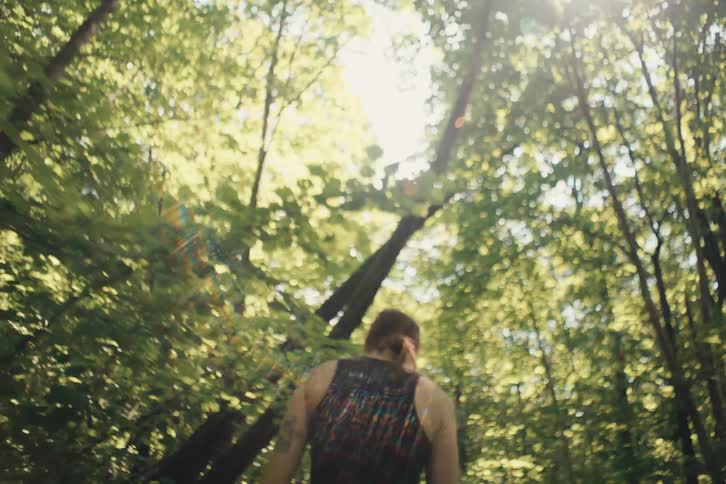 The woman is hiking through the forest on a sunny day