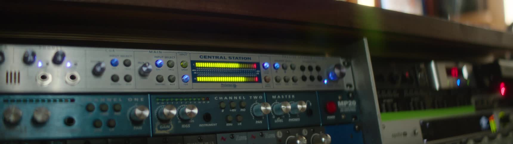 Audio studio rack shows illuminated level meters and control knobs