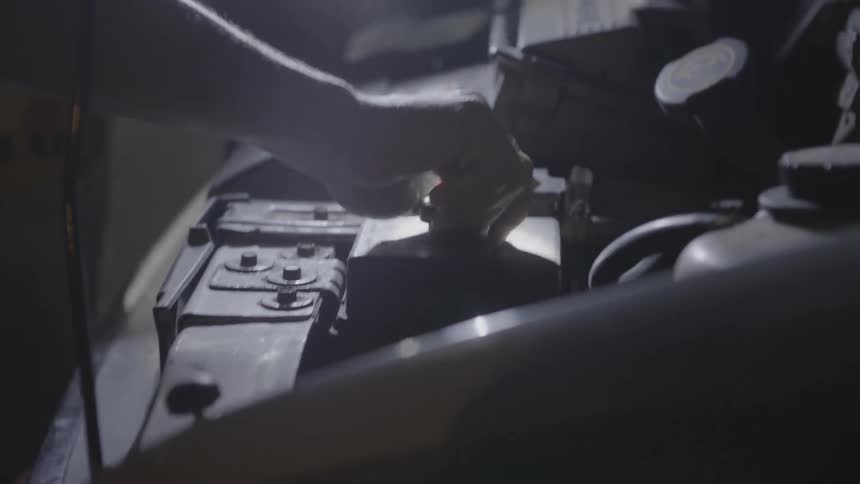 A man is working on the engine of a vehicle