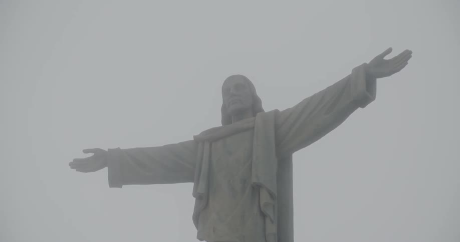 A statue of a man lines the cloudy sky