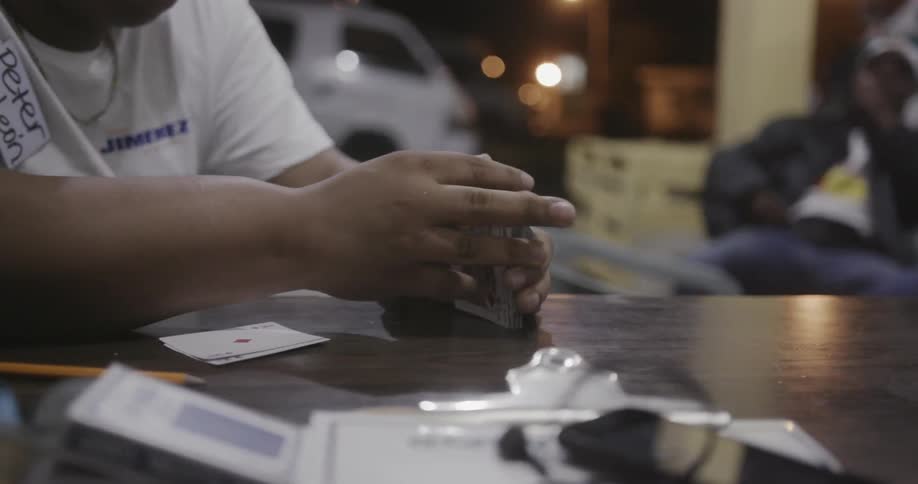 A man is shuffling some cards on the table