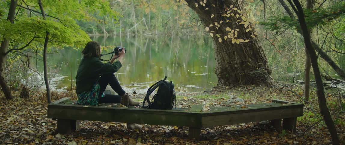 A woman photographs the beauty of nature by the lake