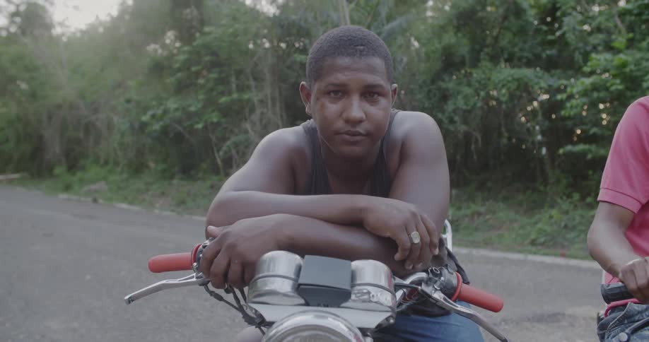 A man sits on a motorcycle and looks forward