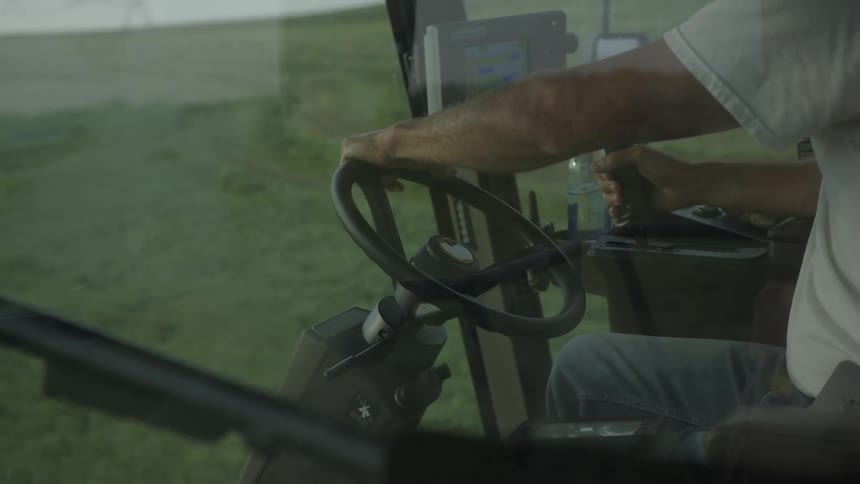 A man operates farm machinery