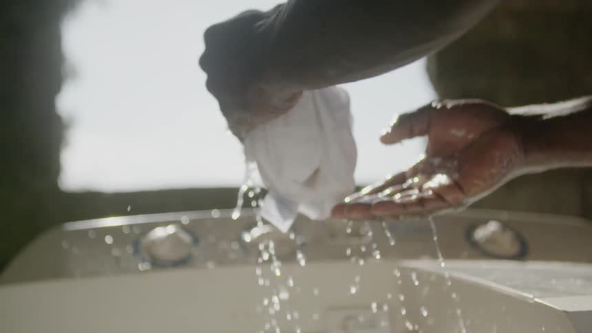 A man is wringing out a washed shirt