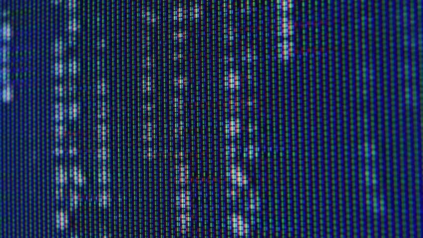 Closeup of screen pixels forming a blue pattern with scattered white dots