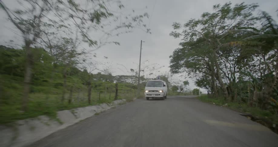 Emergency vehicle driving fast down road on overcast day