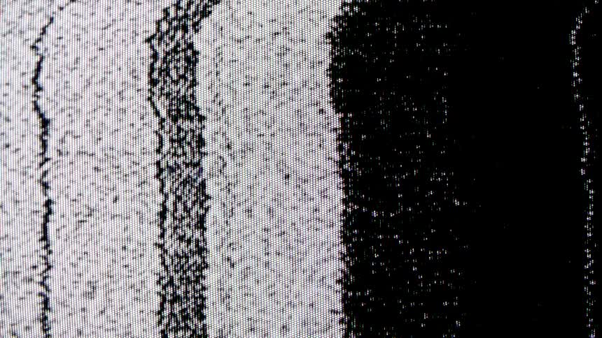 Television screen shows vertical black and white stripes with static noise