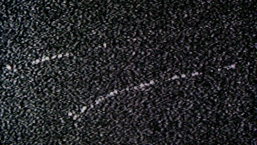Screen displays black and white static noise with a dense pattern