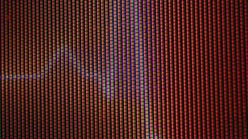 A digital screen showing individual red green and blue subpixels are arranged in vertical lines