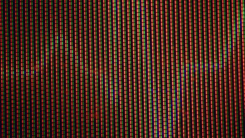 Closeup of screen pixels lit in red green and blue forming vertical stripes