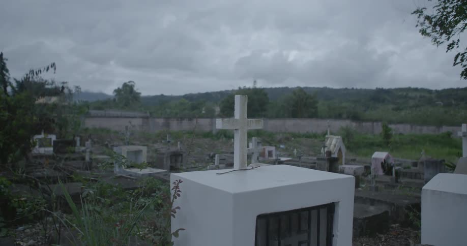 A Cross is Shown in a Cemetery on a Cloudy Day