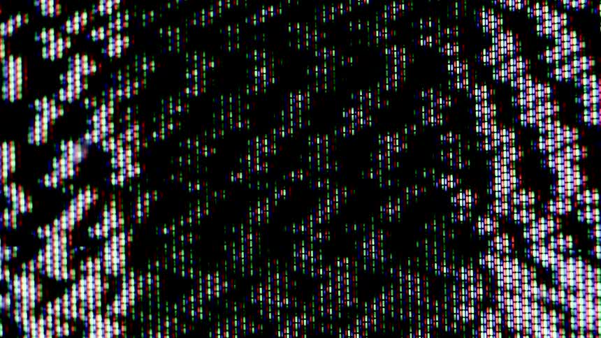 Closeup of illuminated screen pixels forming an irregular pattern of colorful static