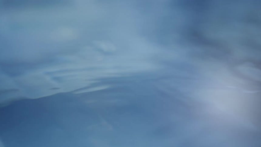 A video shows a light blue abstract background that resembles a soft flowing texture small bright points of light and subtle lens flares move across the frame