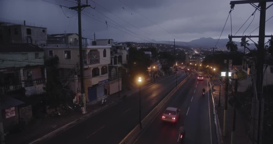 Cars travel on the road below past some homes