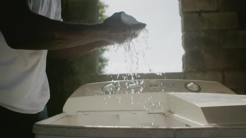 Man wringing water out of wet shirt