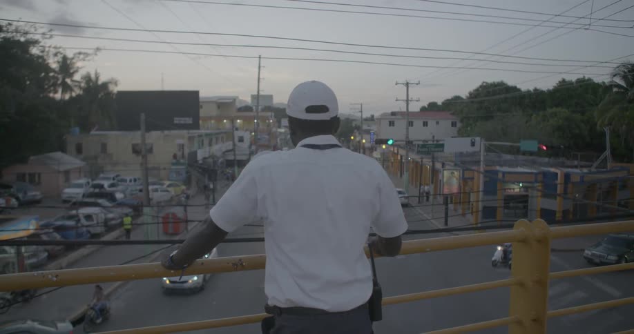 A man in white looks out over a bridge