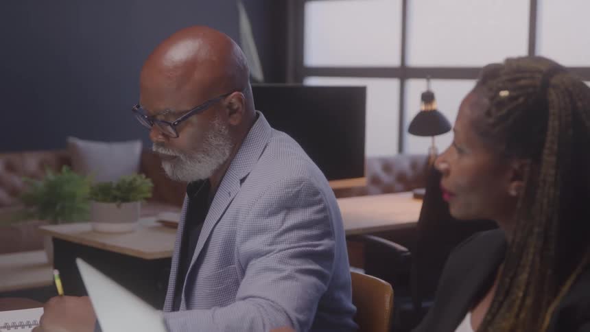 Coworkers write and listen in the office
