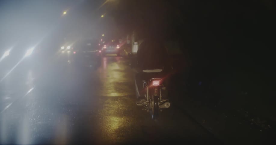 Vehicles travel in the rain at night