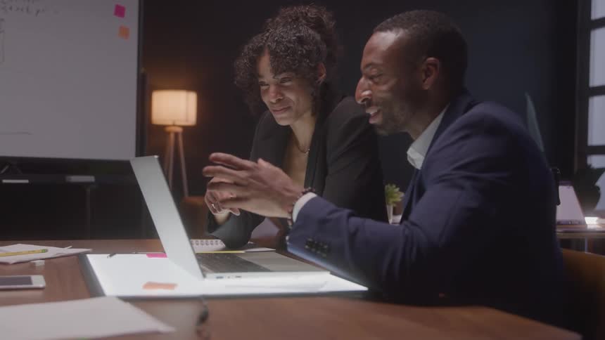 Relaxed meeting between colleagues reviewing data on the laptop