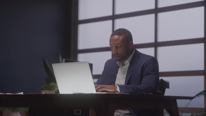 Man in a suit working on a glowing laptop