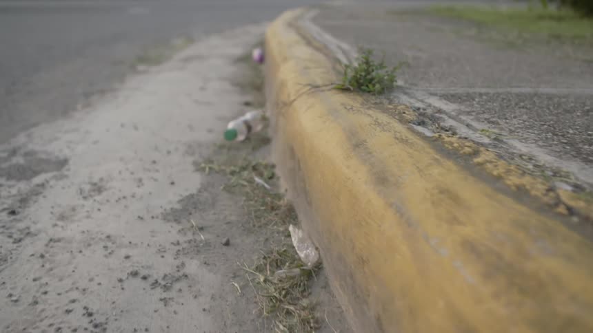A curb littered with dirty trash