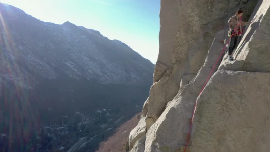 Person climbing a mountain during the day