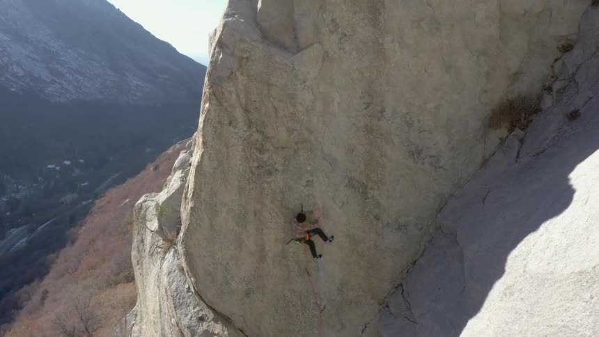 Person adventuring climbing on a cliff of a mountain wall