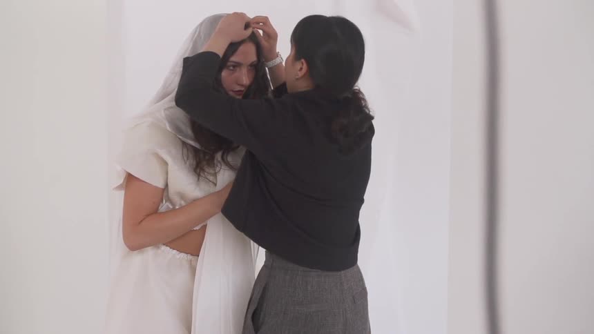 Woman adjusting some clothing on a model